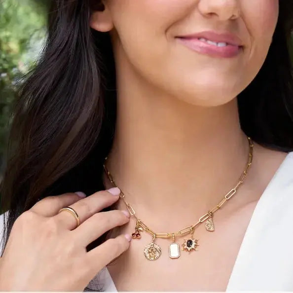 Woman wearing a gold necklace with charms, with text indicating the necklace's details.
