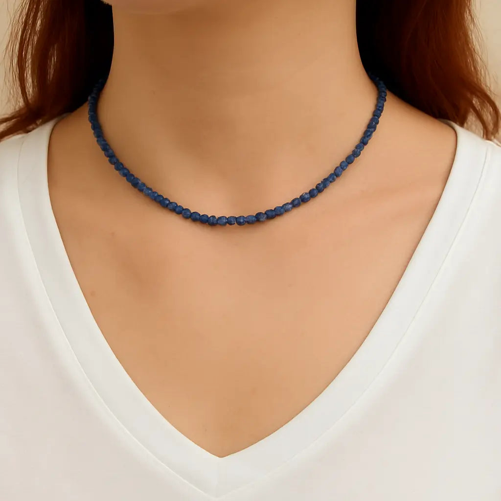Navy blue beaded necklace worn by a person on a neutral background